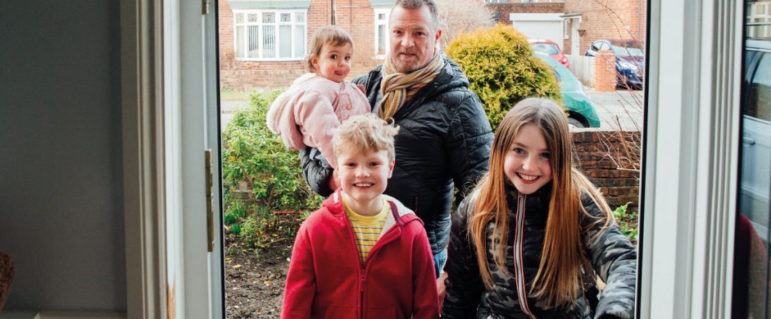 A family walking in the front door of their house