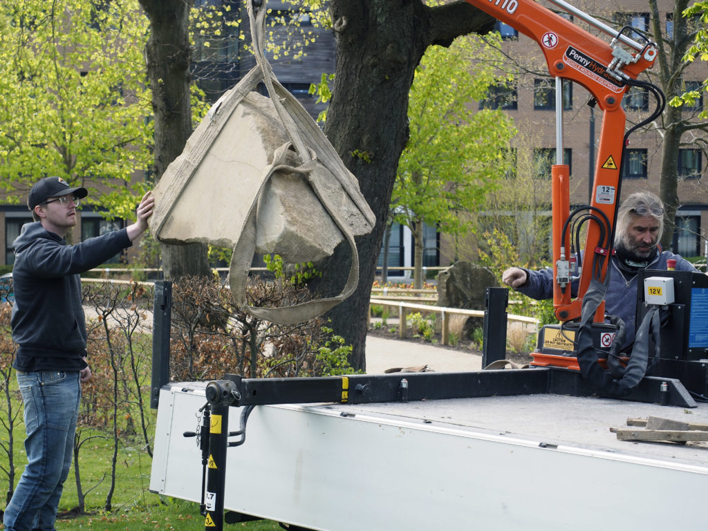 Lifting the boulder into place before installing the plaque