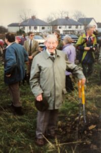 Gerald smiling, leaning on spade